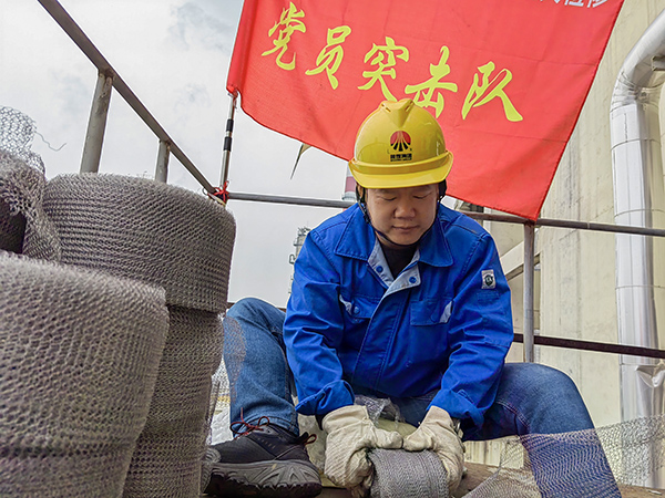5月10日中午，在動(dòng)力車間三期工藝除氧器平臺(tái)上，黨員突擊隊(duì)隊(duì)長李鑫正在纏繞新填料.jpg