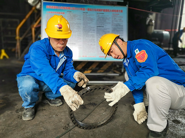 圖三：12日下午14時，在一期磨煤機廠房，陜西省技術能手姬霄給青工張跟潮講解磨煤機搖臂曲拐內環及動作原理。.jpg